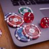 Laptop on Table with Casino Chips Spread Out
