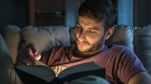 Guy Reading Book On Couch