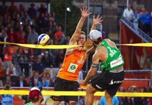Brazil's Bruno Oscar Schmidt spikes the ball onto the net as Netherlands' Christiaan Varenhorst defends, during the FIVB Beach Volleyball World Championships men's final game in The Hague, Netherlands on Sunday, July 5, 2015. (AP Photo/Phil Nijhuis)