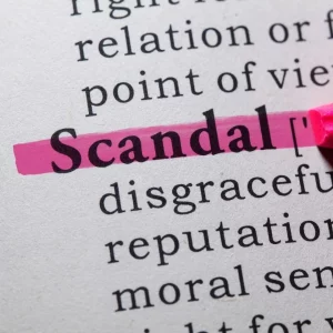 Close-up of a dictionary page with the word ‘Scandal’ highlighted in pink