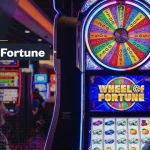 Wheel of Fortune slot machine with a colorful bonus wheel and reels on a casino floor, featuring “Wheel of Fortune Slots” branding.
