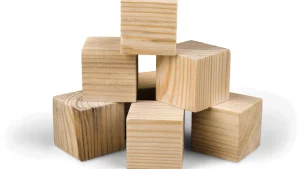 Stack of unfinished wooden blocks arranged against a white background.