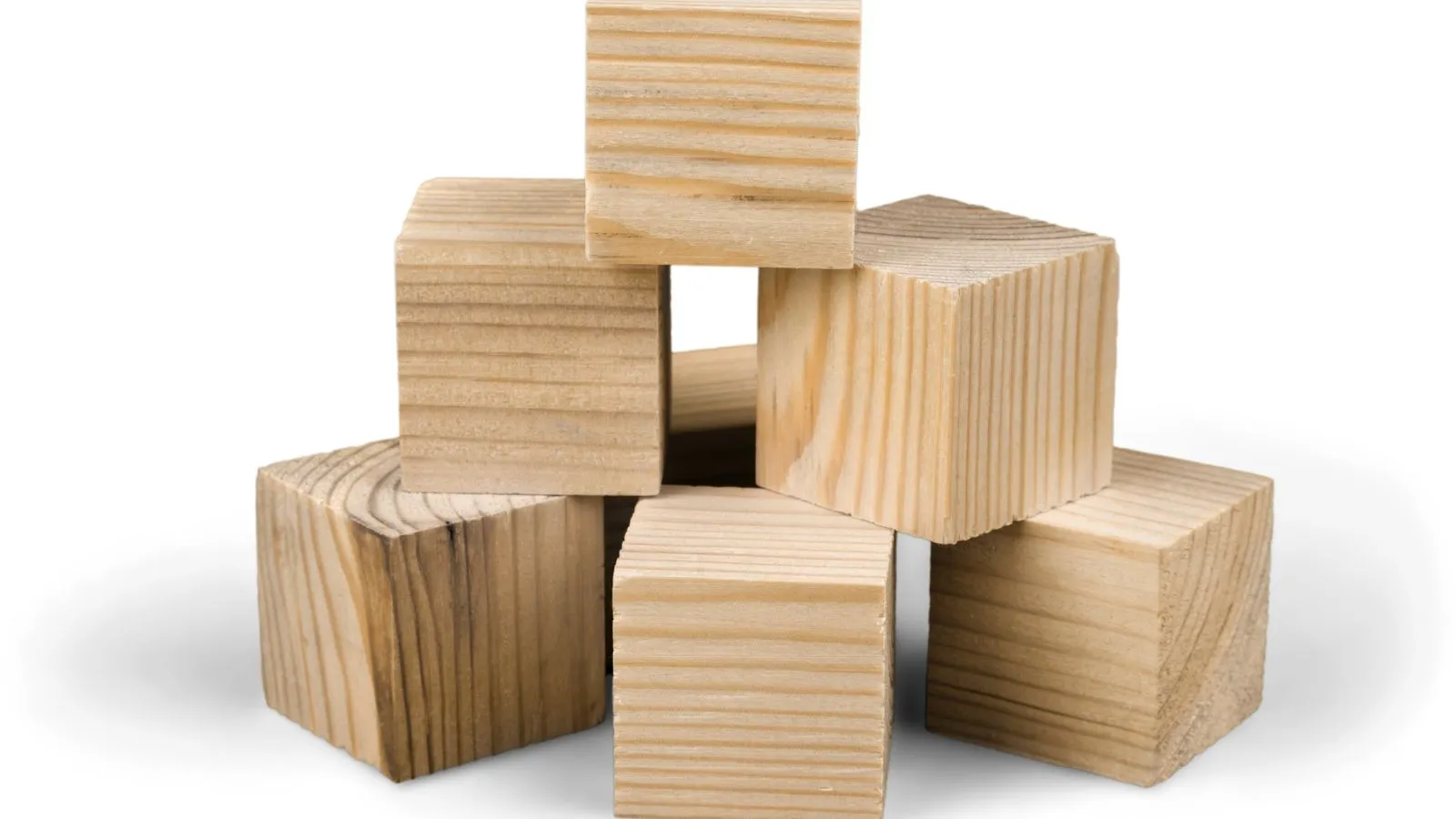 Stack of unfinished wooden blocks arranged against a white background.