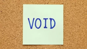 Sticky note with the word “VOID” pinned to a corkboard.