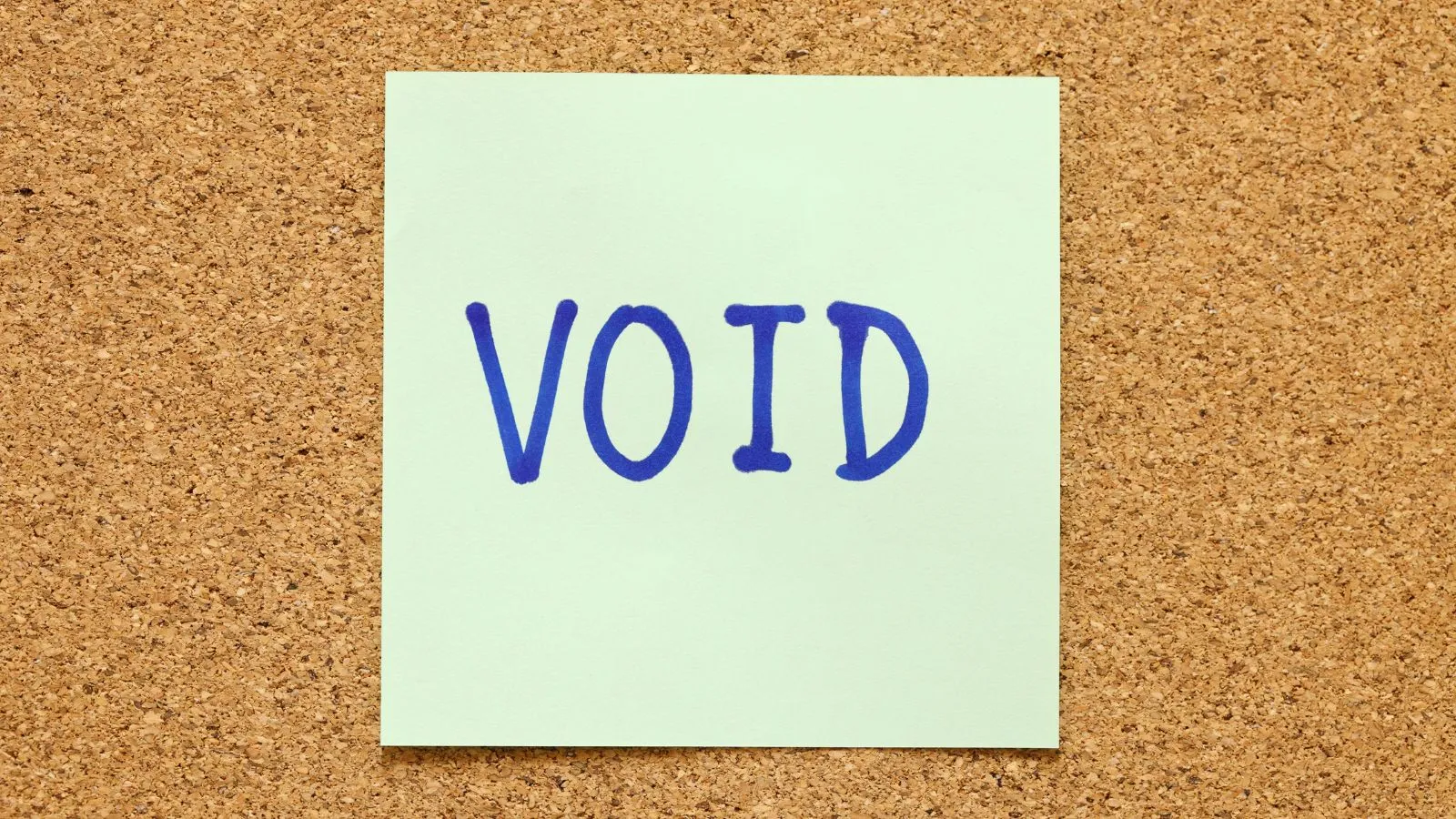 Sticky note with the word “VOID” pinned to a corkboard.