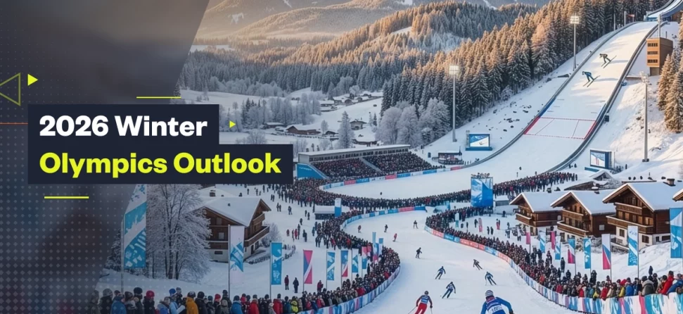 2026 Winter Olympics outlook graphic showing a snowy alpine ski venue with athletes racing downhill, packed spectator stands, mountain chalets, and a large ski jump in the background