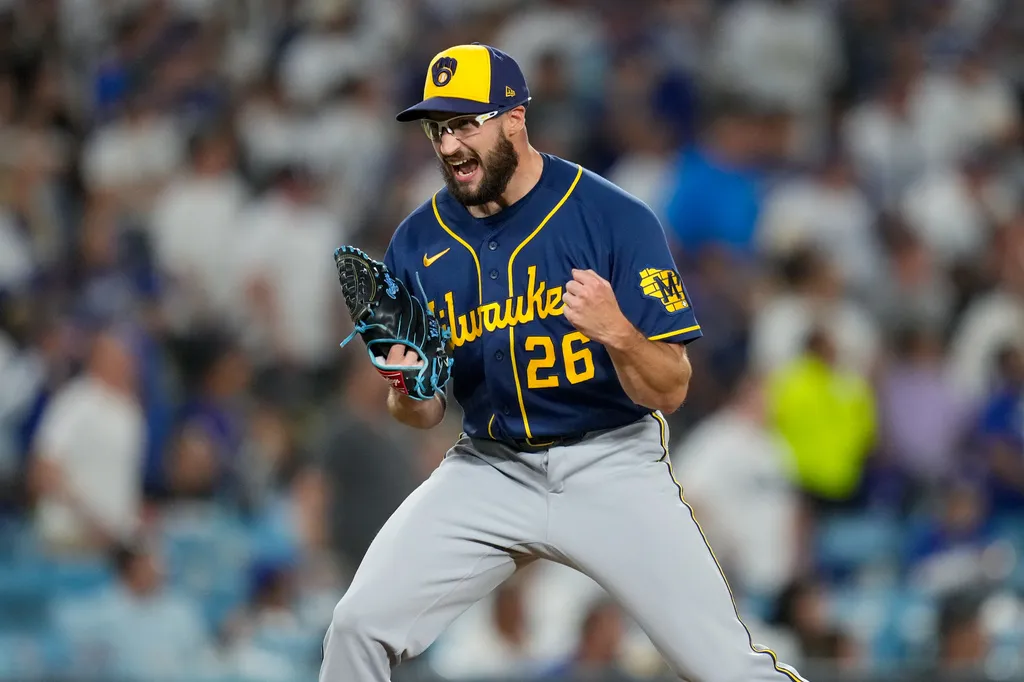 Milwaukee Brewers pitcher wearing number 26 celebrates with a clenched fist and his glove raised.