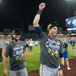 Milwaukee Brewers players celebrate their National League championship at Dodger Stadium, with one raising his fist.